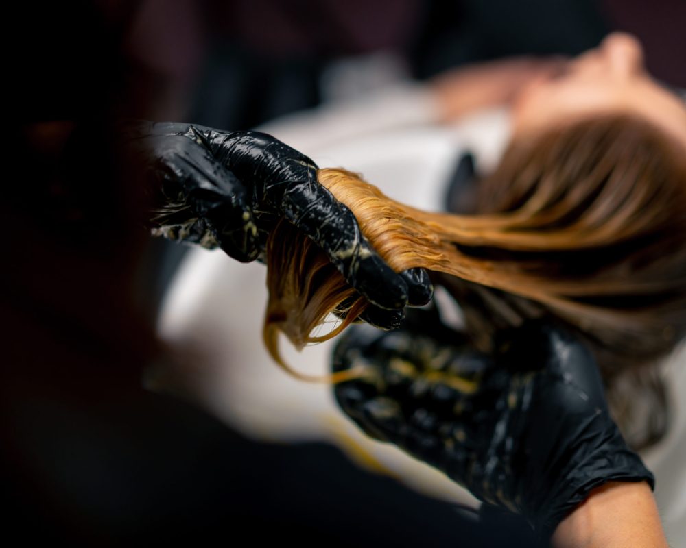 close-up of a hairdresser applying paint to a client’s wet hair in a beauty salon makeover close-up of a hairdresser applying paint to a client's wet hair in beauty salon makeover