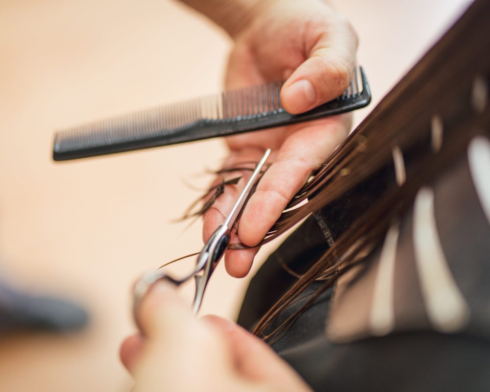 Hair Cutting Close-up of a man hairdresser cutting the hair of a woman.